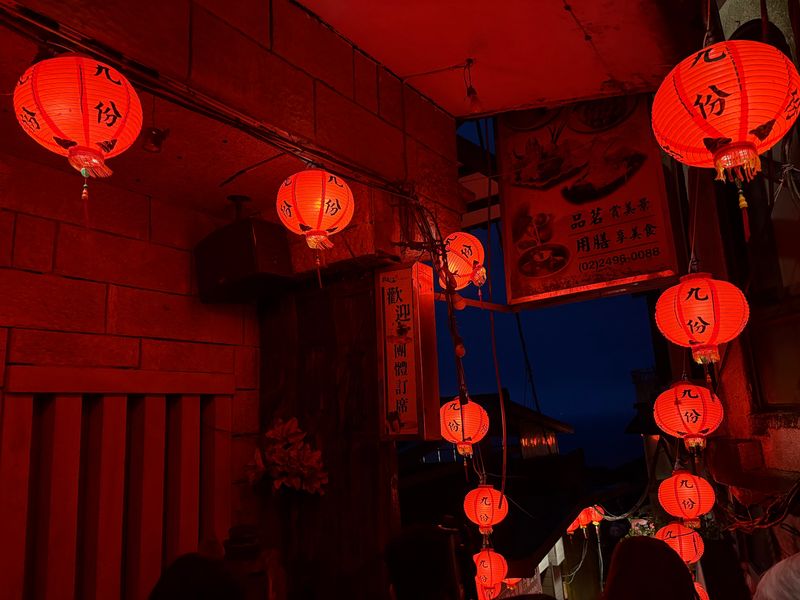 Red paper lanterns glowing over a narrow alley in Jiufen